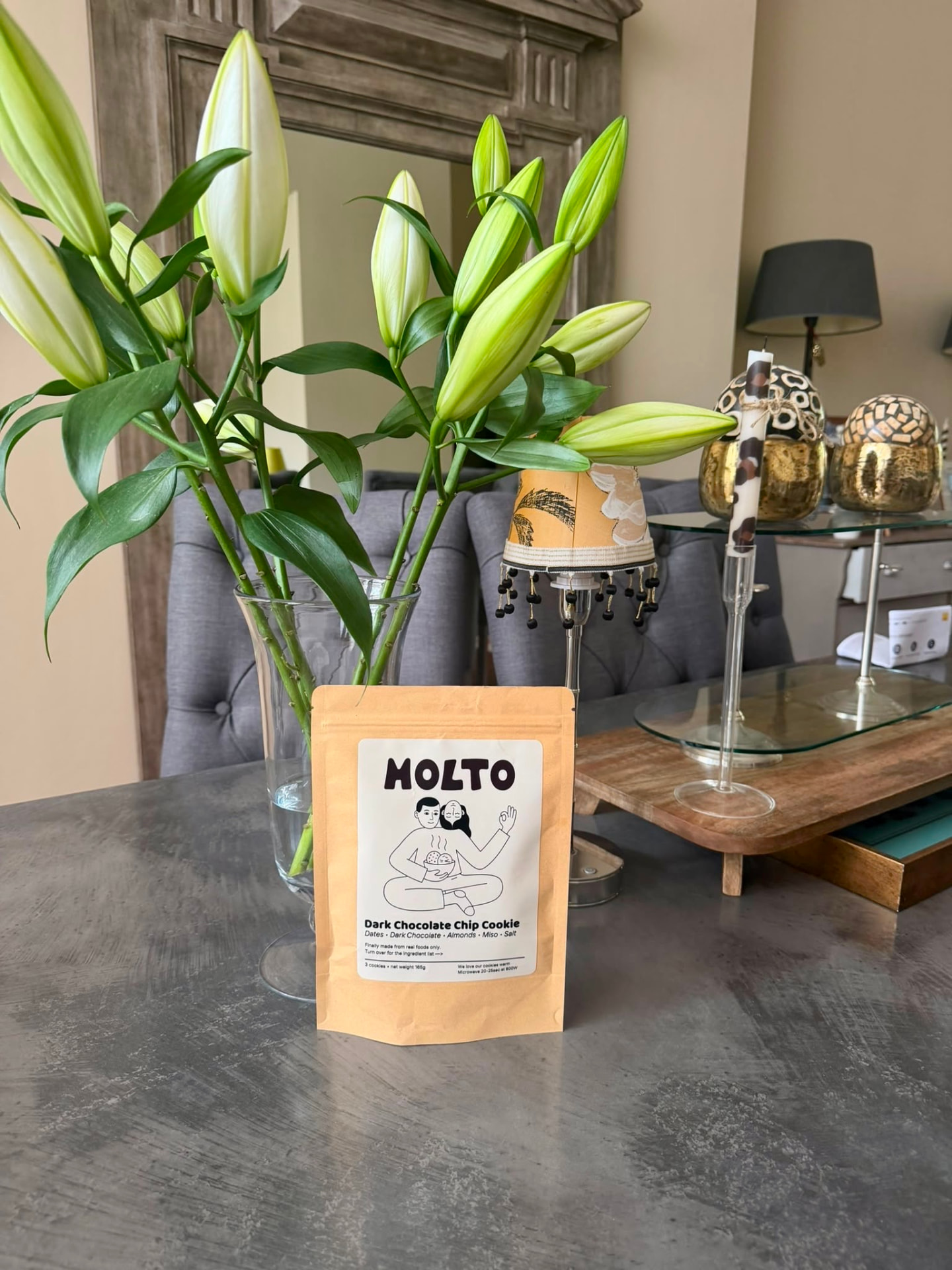 MOLTO pouch on a table beside lilies
